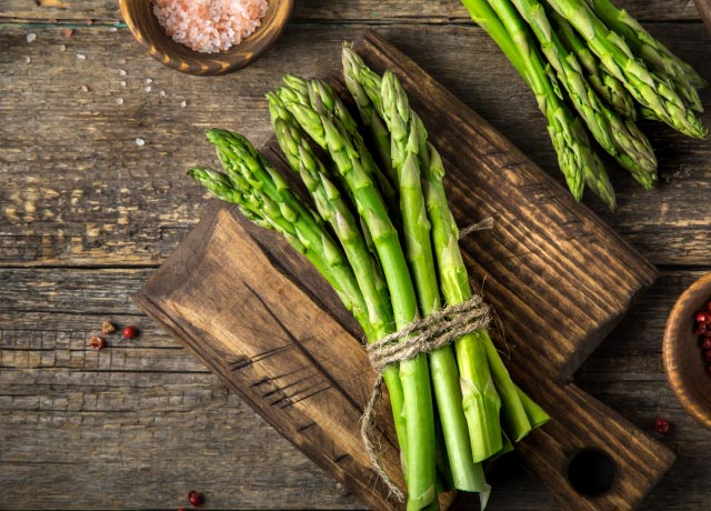 Two bunches of fresh asparagus bound with twine.